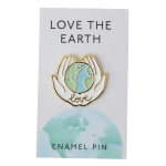 Enamel pin on a card with hands holding the Earth and the words Love the Earth