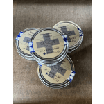 Four small tins of muscle rescue balm on a wooden surface