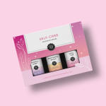 Pink self-care essential oil gift set box with three small bottles on pink background