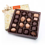 Box of assorted chocolates with a ribbon-tied gift box behind it