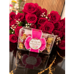 Red roses with a box of strawberry cream candies in front