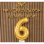 Gold number 6 balloon in front of a flower shop sign