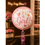 Pink balloon reading "It's a Girl!" with a ribbon and weight