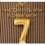 Gold number 7 balloon in front of a flower shop sign