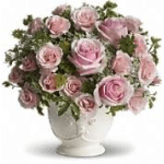 Pink roses arranged in a white pedestal vase