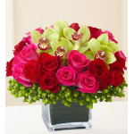 Pink and red roses with green orchids in a square glass vase