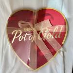 Heart-shaped box of Pot of Gold chocolates tied with a ribbon