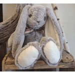 Plush gray bunny with long ears and a plaid bow sitting on a wooden bench