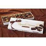 Box of assorted chocolates with a ribbon on a brown fabric surface