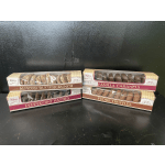 Four boxes of assorted chocolates stacked on a dark surface