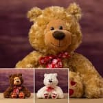 Plush teddy bear with a red heart-patterned ribbon, shown with two smaller bears.