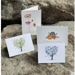 Four floral greeting cards displayed on rocks