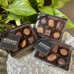 Boxes of assorted chocolates on a bed of green leaves