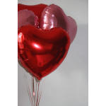 Heart-shaped red and pink balloons tied together