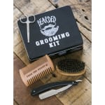 Beard grooming kit in a black tin with comb, brush, scissors, and razor