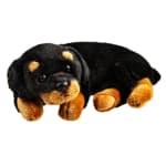 Plush black and tan puppy lying down on a white background