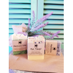 Three wrapped soap bars with lavender sprigs behind them