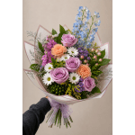 Hand-tied bouquet of roses, chrysanthemums, and carnations in pastel wrap