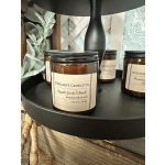 Amber jar candles on a black tray with a lamp and decor