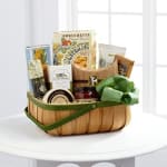 Gift basket with assorted packaged snacks and a green bow