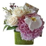 Bouquet of white roses, pink hydrangea, and white orchids in a green wrap