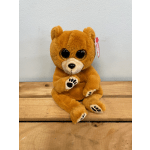 Orange plush teddy bear with glittery eyes sitting on a wooden surface