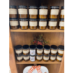 Shelves of labeled jar candles with a plaid ribbon on a gift basket below