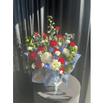 Bouquet of red, white, and blue flowers wrapped in pale blue paper