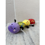 Four colorful plush caterpillar toys lined up on a floor