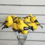 Yellow decorative bird picks in a clear glass vase