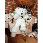 Three plush teddy bears in a basket on a wooden chair
