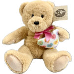 Plush teddy bear holding a heart-patterned pillow with a pink ribbon