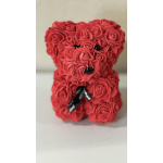 Red rose-covered teddy bear figurine with black eyes, nose, and ribbon