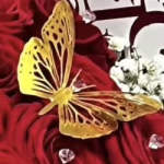 Yellow butterfly resting on deep red fabric with white flowers nearby