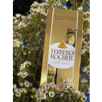 Ferrero Rocher chocolate box surrounded by small white-pink flowers