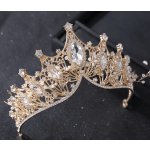 Gold jeweled crown with clear crystals on a black box