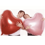 Couple holding large heart-shaped balloons, one red and one pink