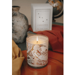 Lit candle in a glass jar with a decorative label