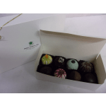 Box of assorted decorated chocolates in a white gift box
