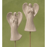 Two white ceramic angel ornaments on sticks against a green background
