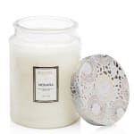 White candle in a glass jar with a decorative lid