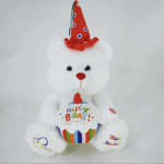 White teddy bear wearing a birthday hat and holding a birthday cupcake