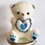 White teddy bear with blue paw prints and a heart on its chest