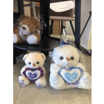 Three plush teddy bears in plastic wrap, two with heart-shaped "I Love You" accents.