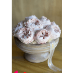 Pale pink roses arranged in a low round box