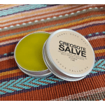 Two small tins of creosote salve on a striped woven textile.