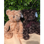 Two plush teddy bears with ribbons against a leafy backdrop