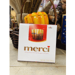 Box of Merci chocolates in front of a decorative pumpkin display