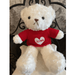 White plush teddy bear in a red heart sweater sitting on a decorative metal chair
