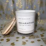 White candle jar with a wooden lid labeled Relaxation